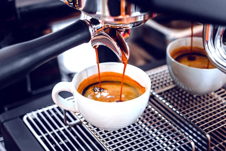 Espresso pouring into cup at home